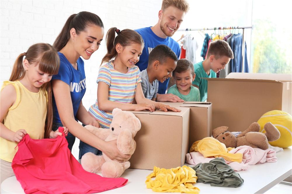 Children and volunteers sorting clothes and toys.